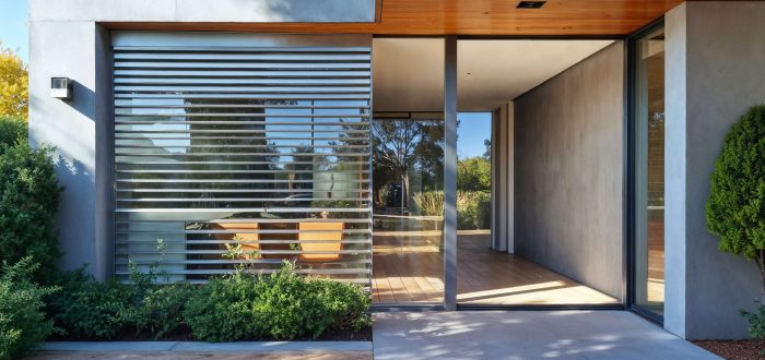 Detailansicht eines modernen Neubaus mit großen Fensterflächen und überdachter Terrasse, umgesetzt von Pradabau als Bauunternehmen im Raum München mit hohem Anspruch an Qualität und Design.