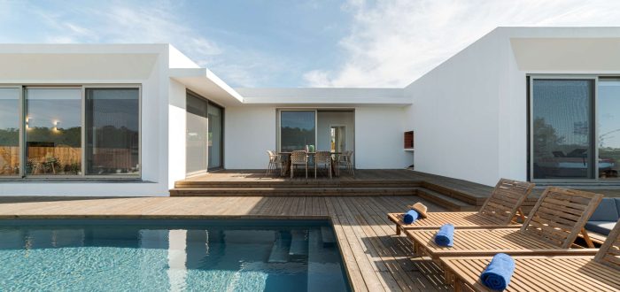Minimalistisches Einfamilienhaus mit Pool und großzügiger Terrasse, geplant und gebaut von Pradabau als Bauträger im Raum Ammersee mit Fokus auf klare Linien und modernes Wohnen.