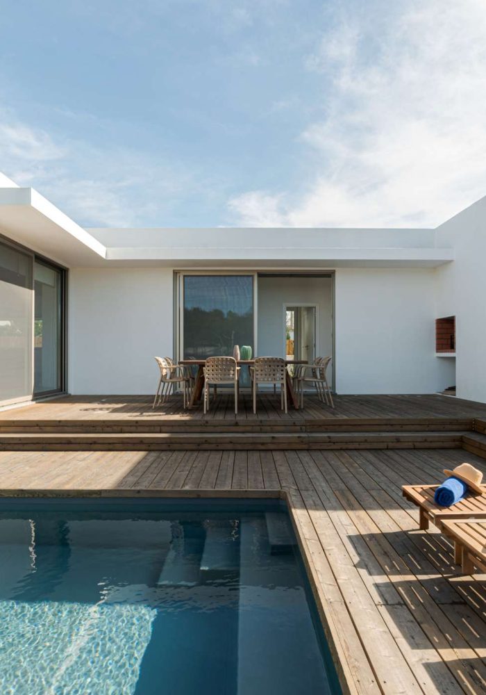 Minimalistisches Einfamilienhaus mit Pool und großzügiger Terrasse, geplant und gebaut von Pradabau als Bauträger im Raum Ammersee mit Fokus auf klare Linien und modernes Wohnen.